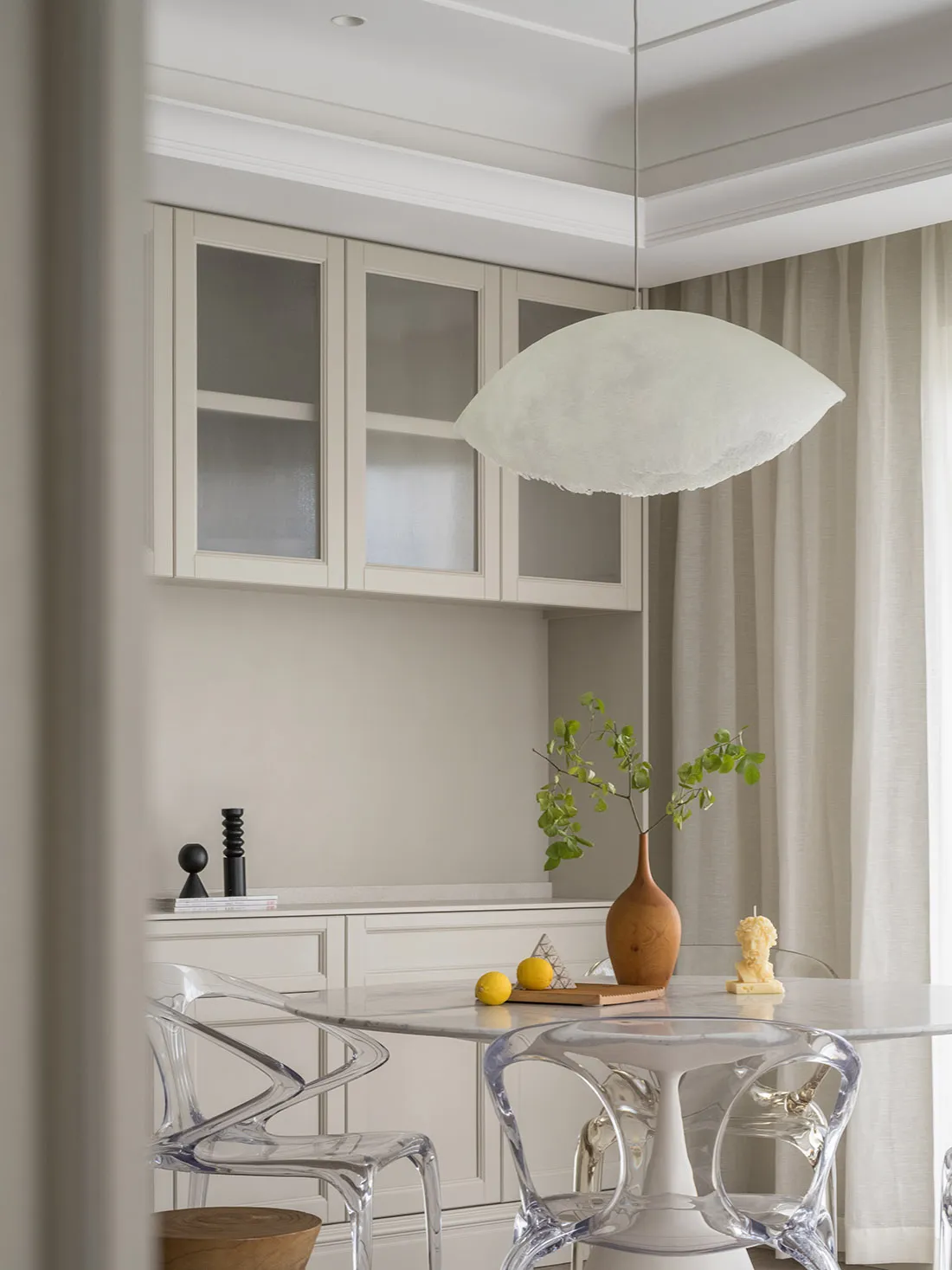 A minimalist kitchen with white marble countertops and cabinets.