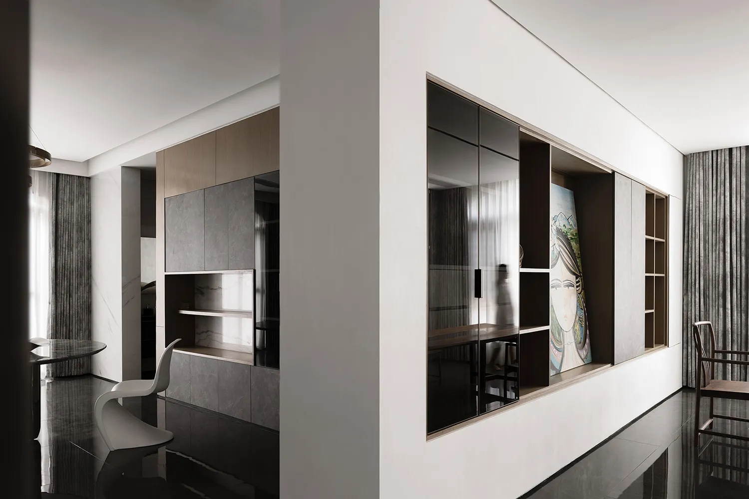 A stylish living space featuring modern metallic black glass panels on the wall and floor.