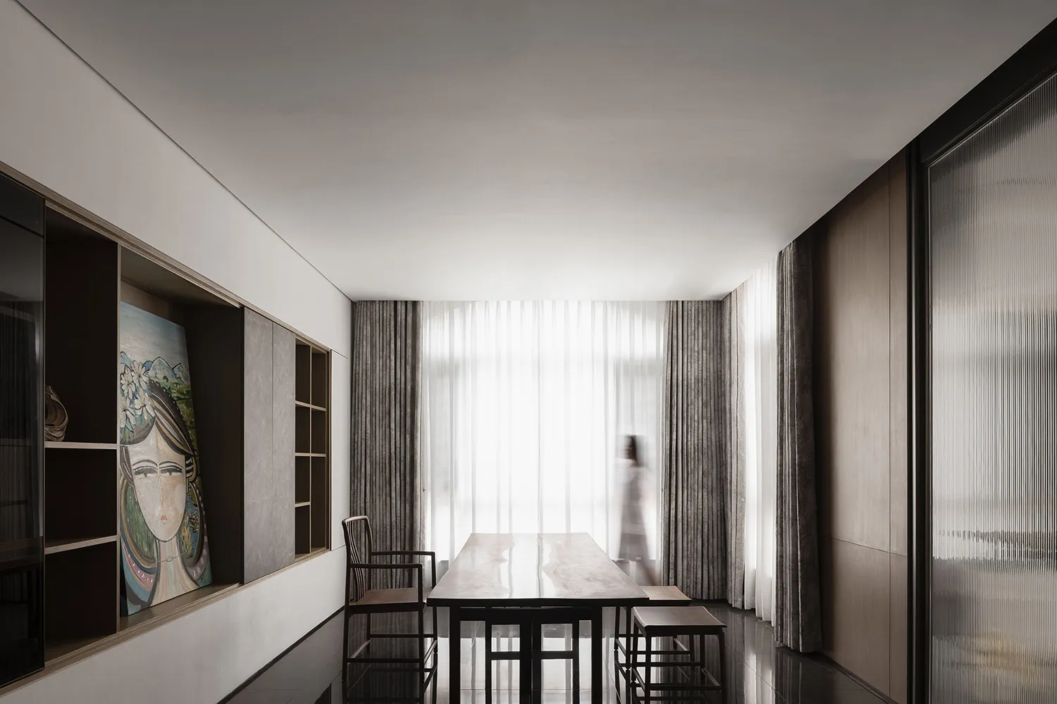 A minimalist dining room with a wooden table, chairs, and curtains.