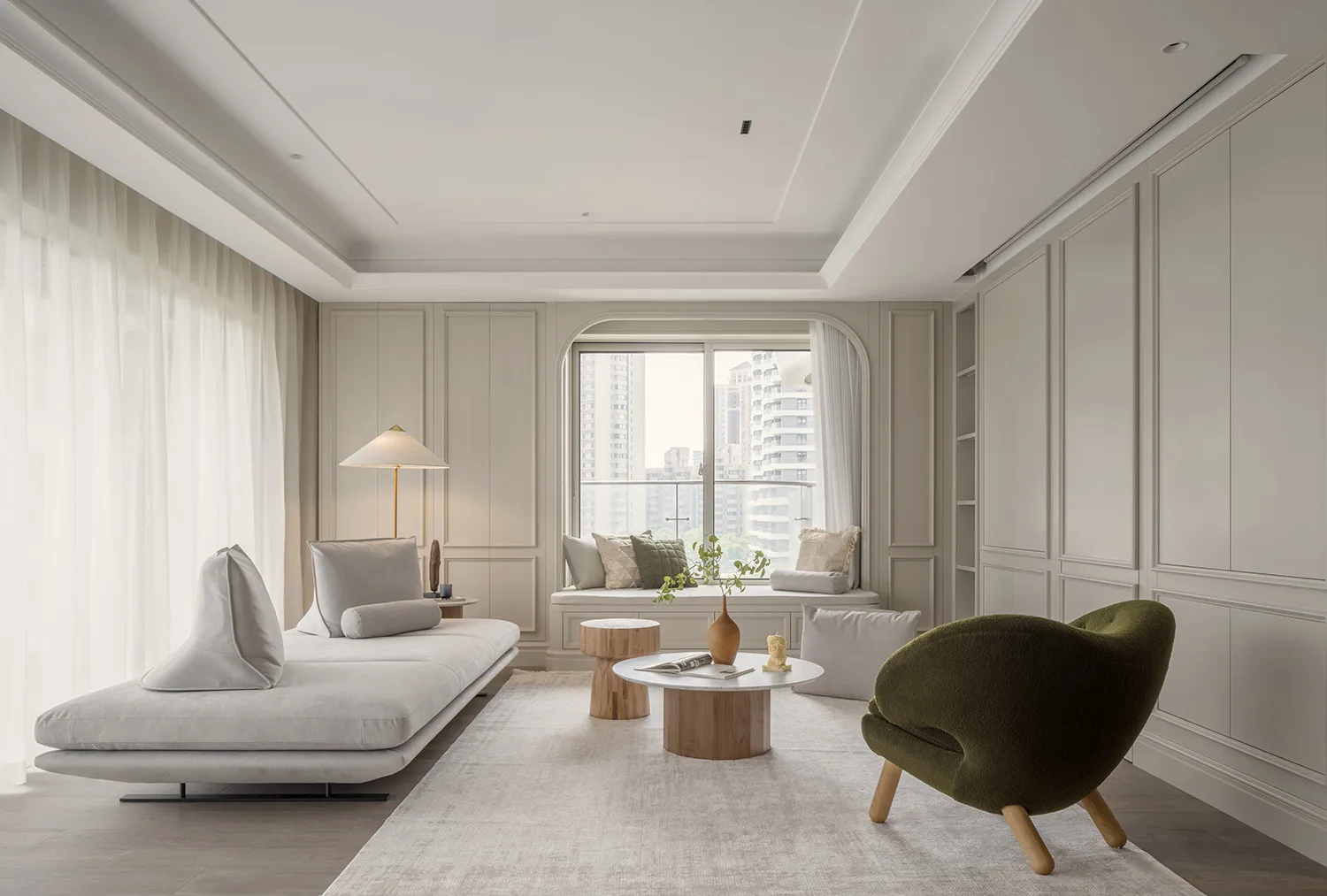 Modern minimalist living room featuring comfortable seating, a coffee table, and large windows with city view.