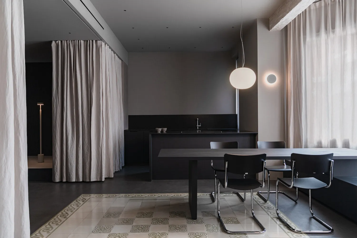 Modern minimalist residential interior with concrete, glass, and beige curtains.