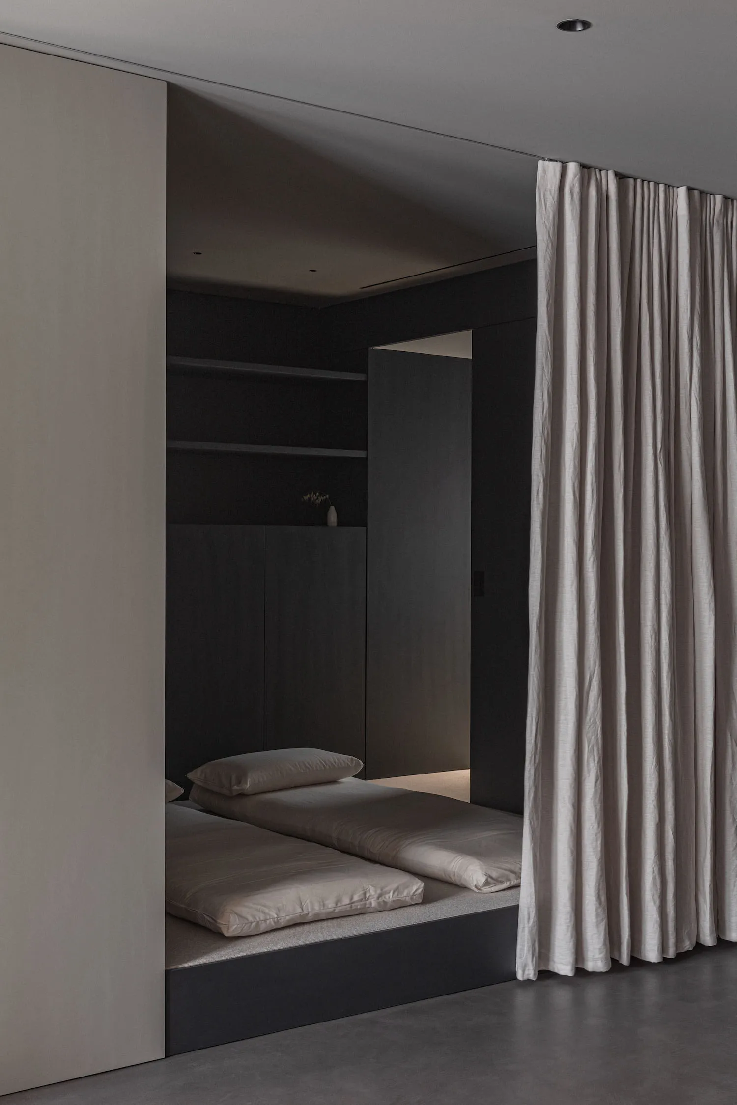 A minimalist bedroom with neutral tones and a simple, modern design.