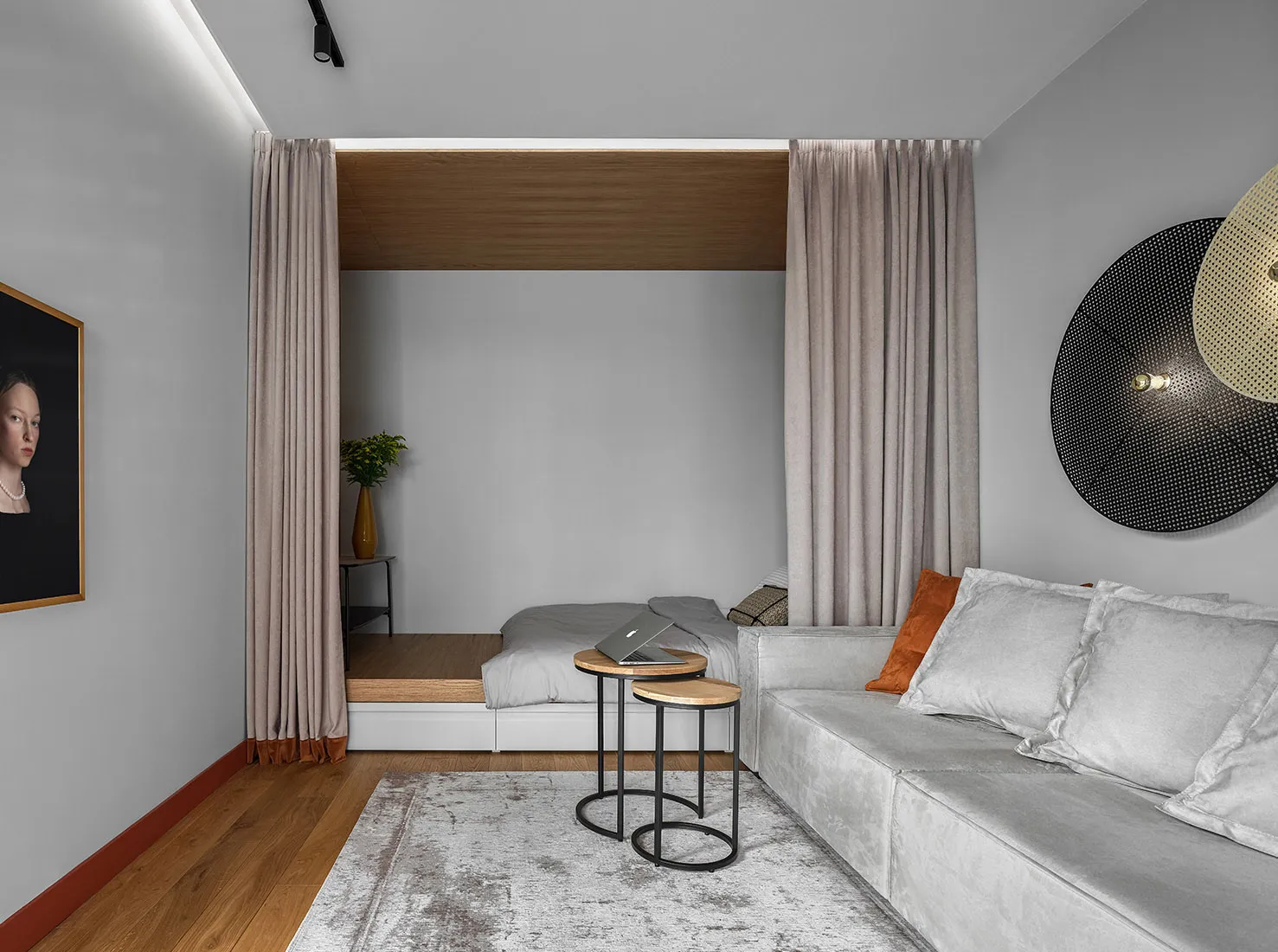 A minimalist living room with grey furnishings, a wooden side table, and a comfortable sofa.