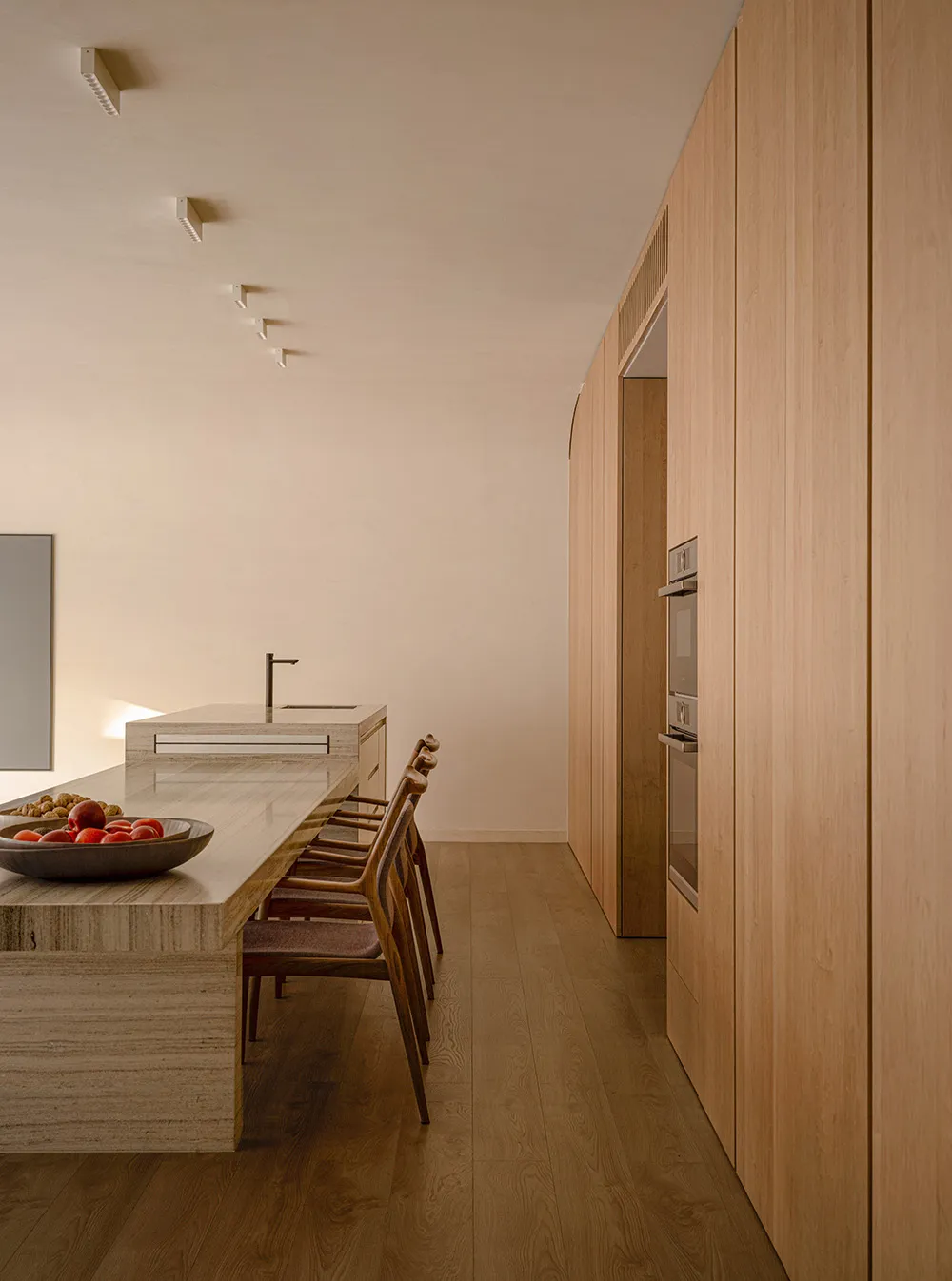 A minimalist residential kitchen featuring a marble countertop and wooden cabinets.
