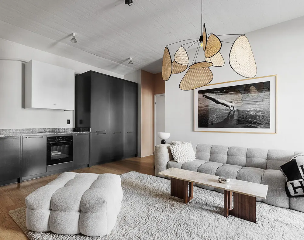 A minimalist living room featuring modern furniture with textured fabrics, wood, and marble surfaces.