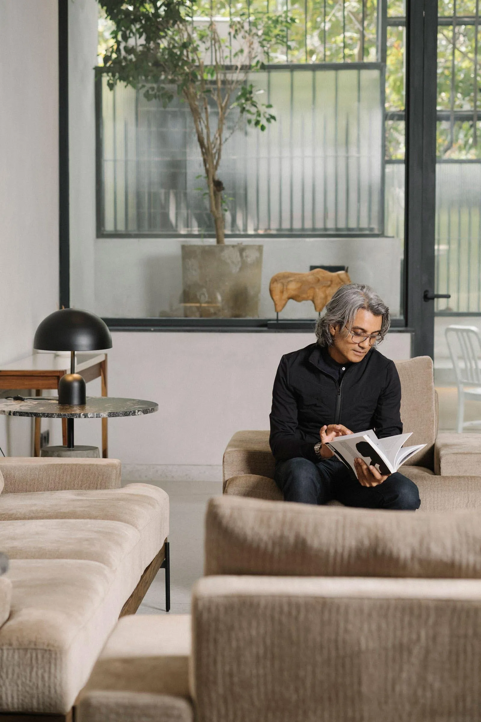 A modern interior space featuring contemporary sofas, glass tables, and leather chairs.