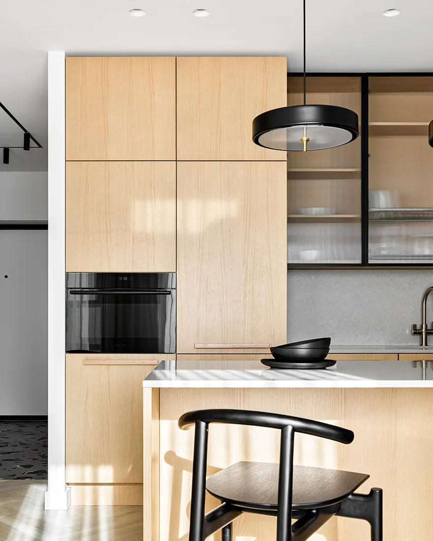 A modern residential kitchen with wooden cabinets and glass features.