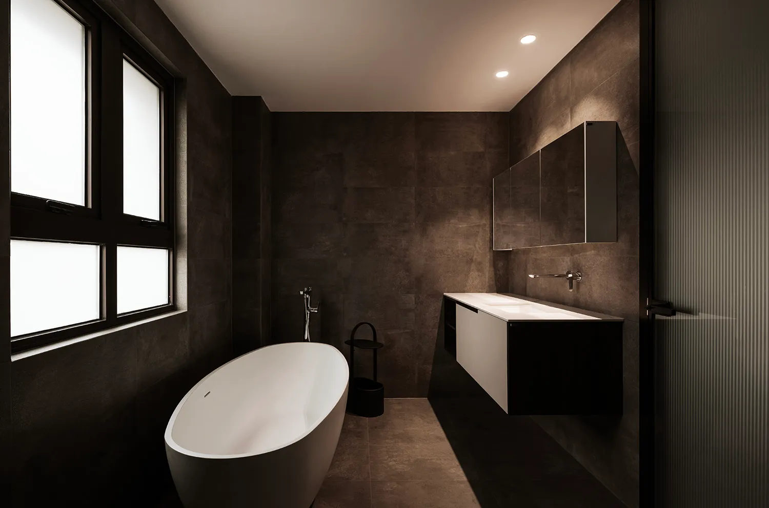 Modern minimalist bathroom featuring concrete tiles, a freestanding bathtub, and a floating vanity with a double sink.