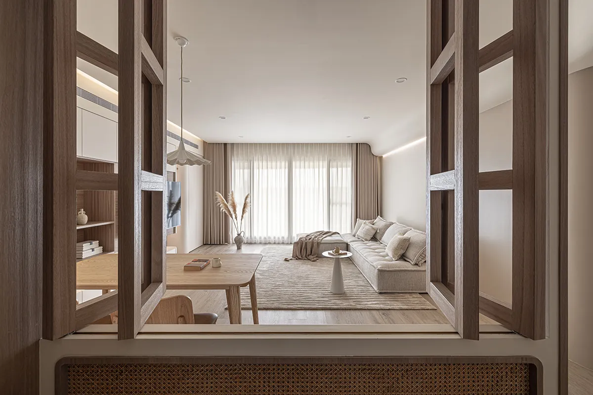 A modern minimalist living room with a cozy arrangement of furniture and a neutral color palette.