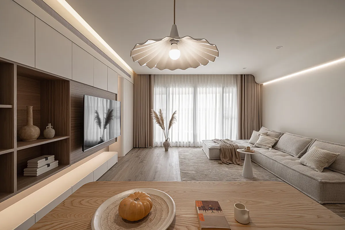 A modern minimalist living room with a sofa, coffee table, and decorative elements.