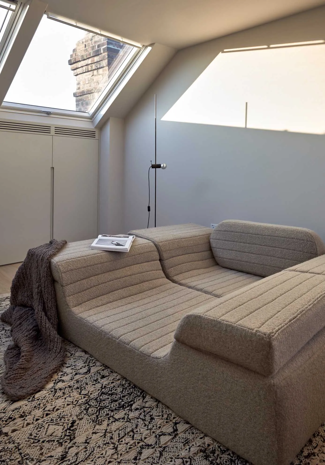 A modern loft living room featuring a white sectional sofa with a fabric upholstery arranged in a floor plan.