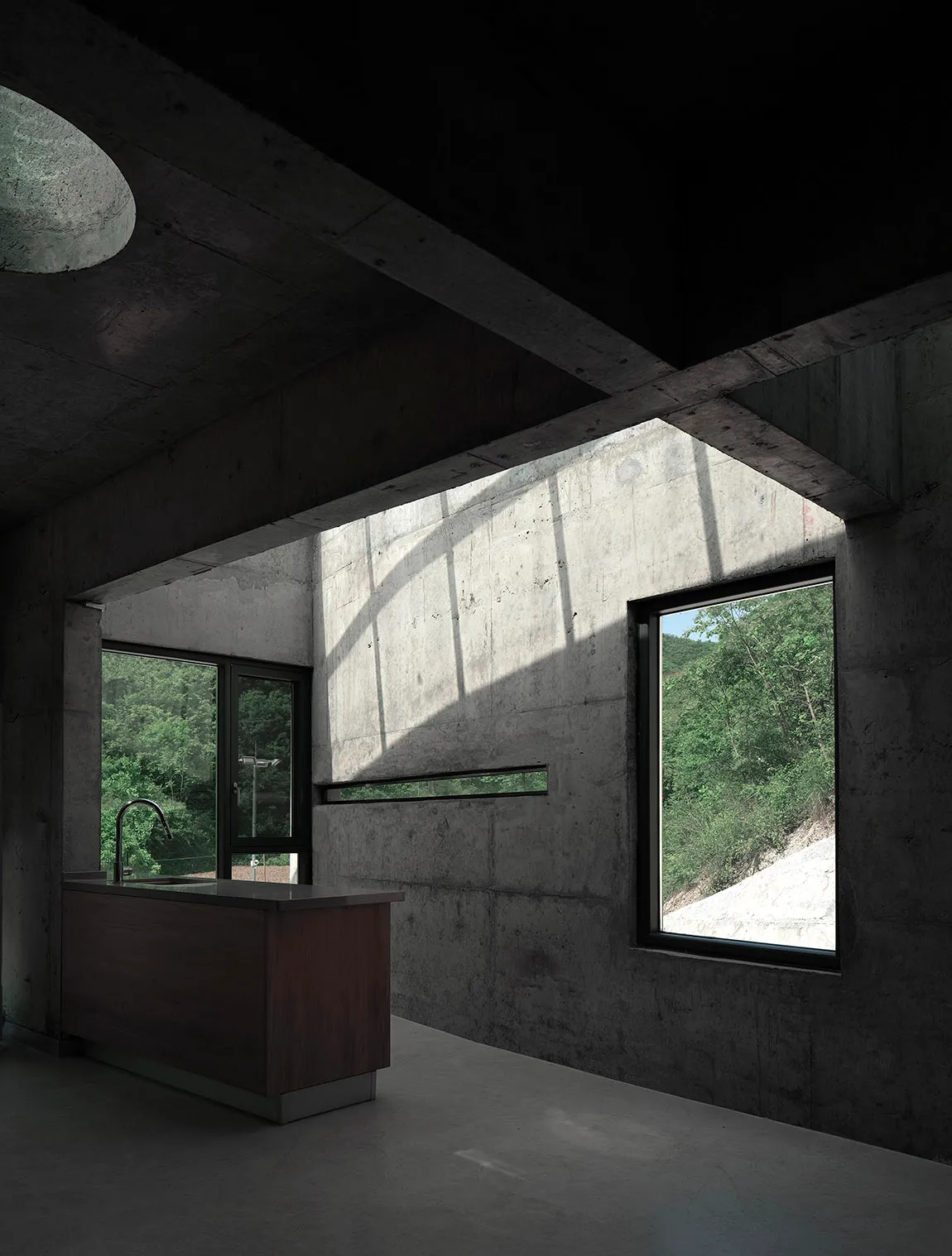A modern kitchen with concrete walls and a dark interior design