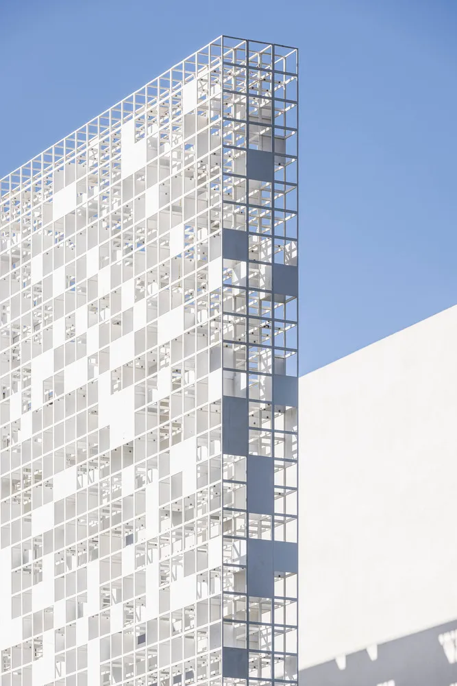 Modern glass office building against a blue sky.