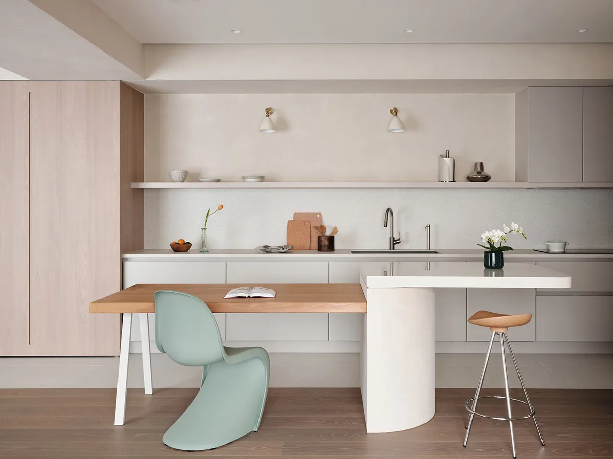 Contemporary kitchen featuring concrete countertops, wooden table, and metallic accents.