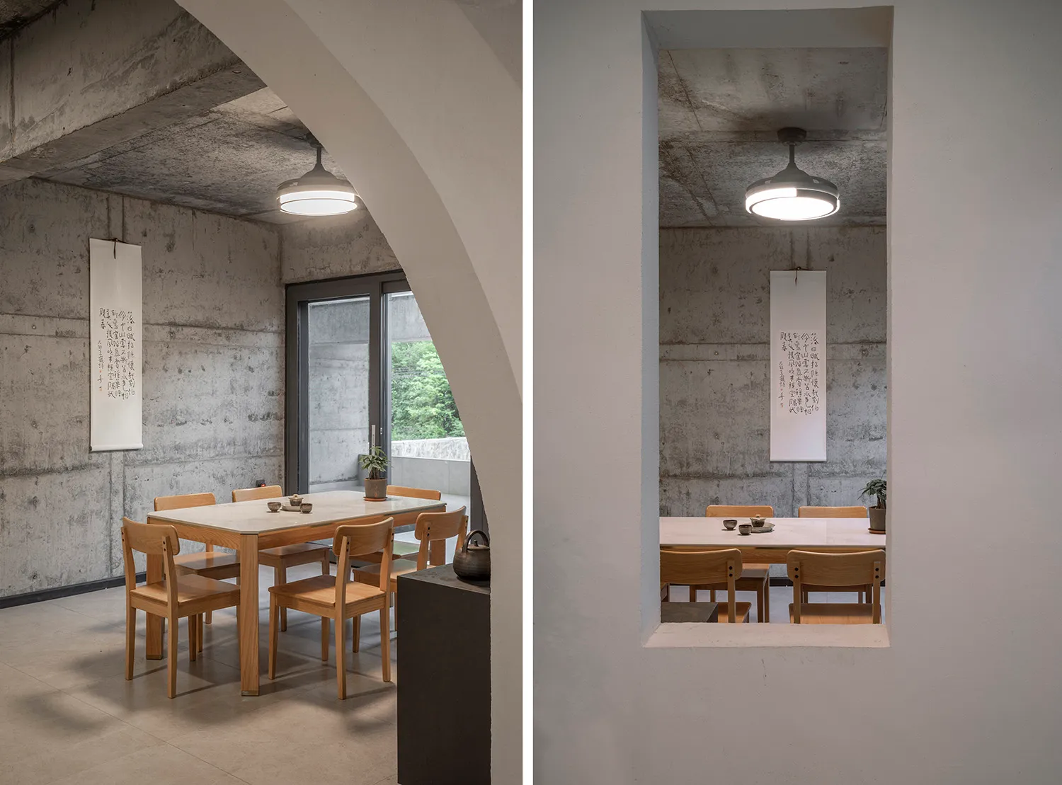 A modern minimalist dining room with concrete walls, wooden furniture, and a ceiling fan.