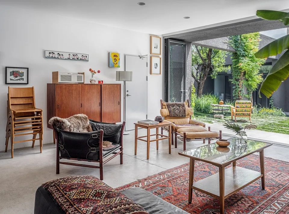 An industrial-style living room with a wooden coffee table and a patterned rug.