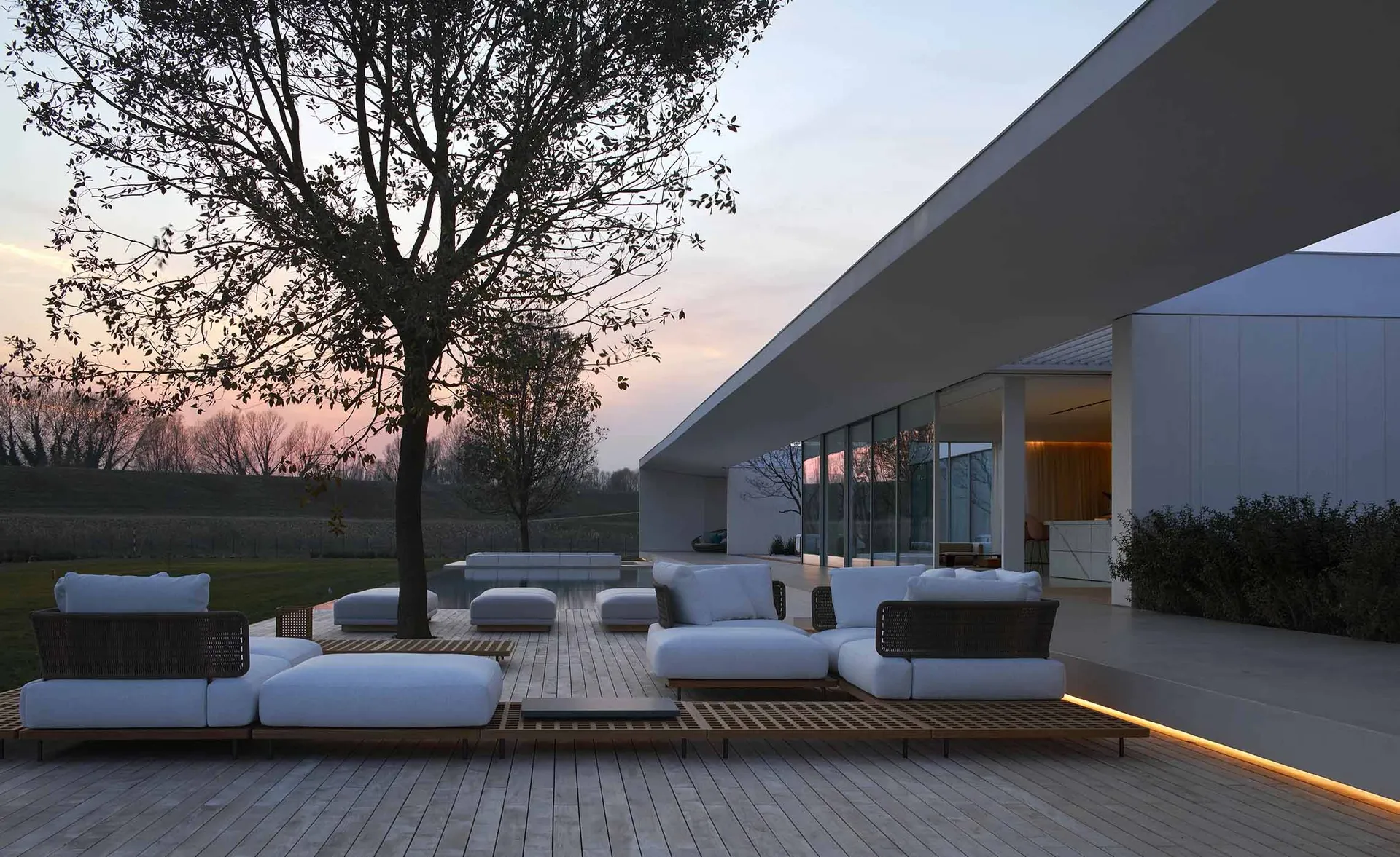 Modern exterior residential space featuring wood, concrete, and glass open-air design