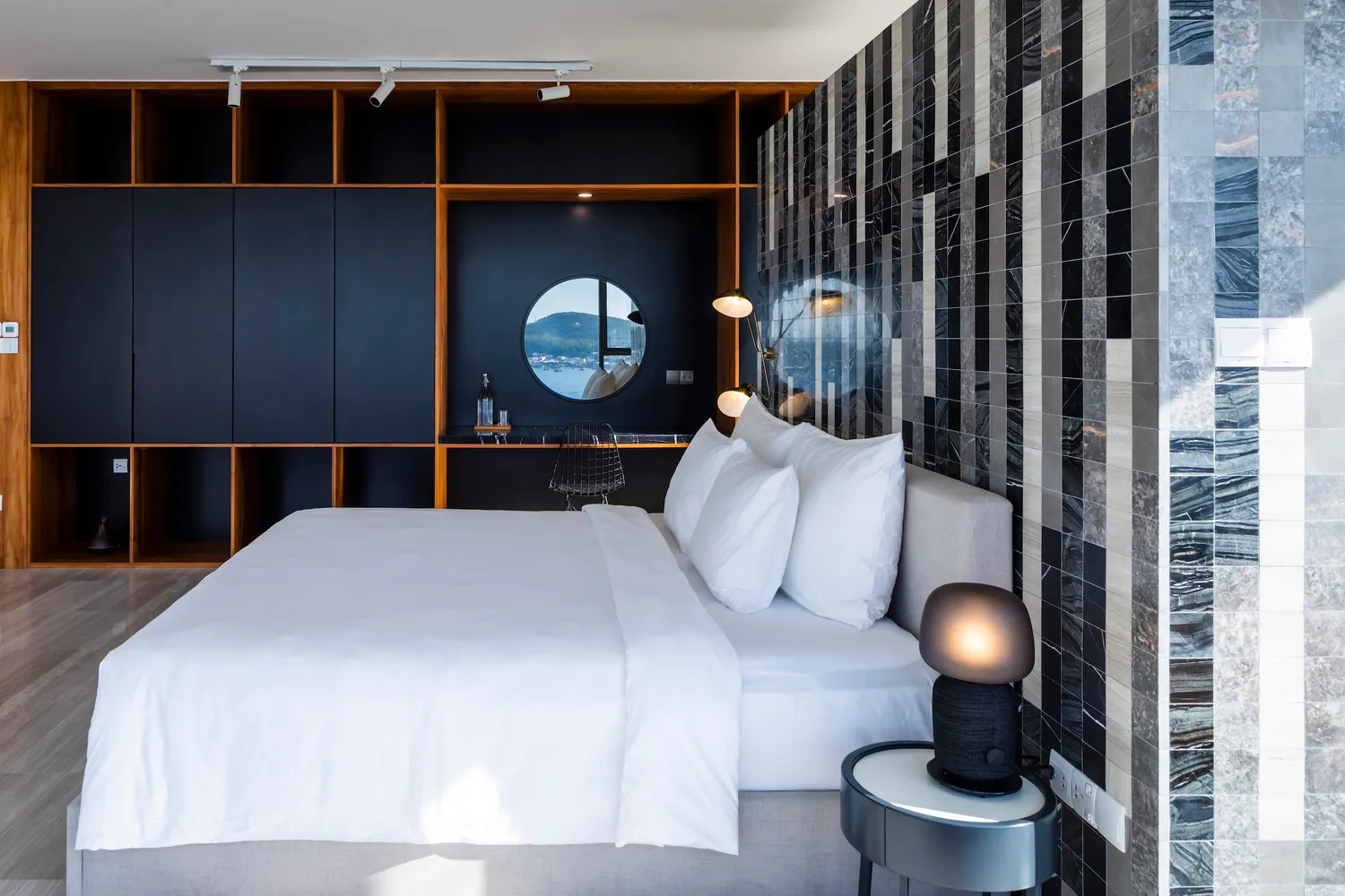 A modern residential bedroom with a white palette featuring a king-sized bed, white bedding, and a mix of modern and minimali