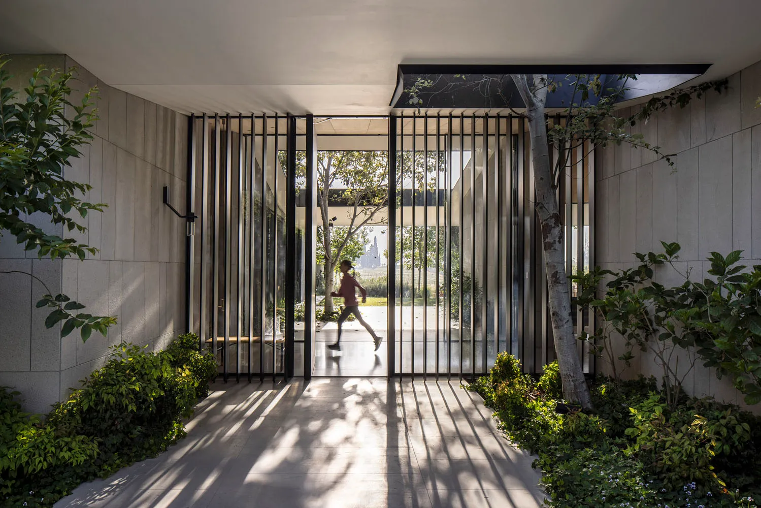 Modern glass entrance with a person running inside.