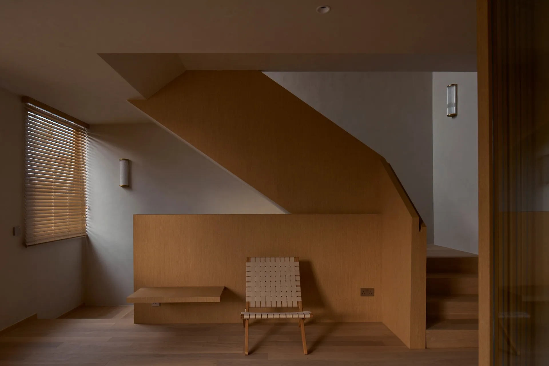 Modern minimalist home office with wooden walls and a single chair.