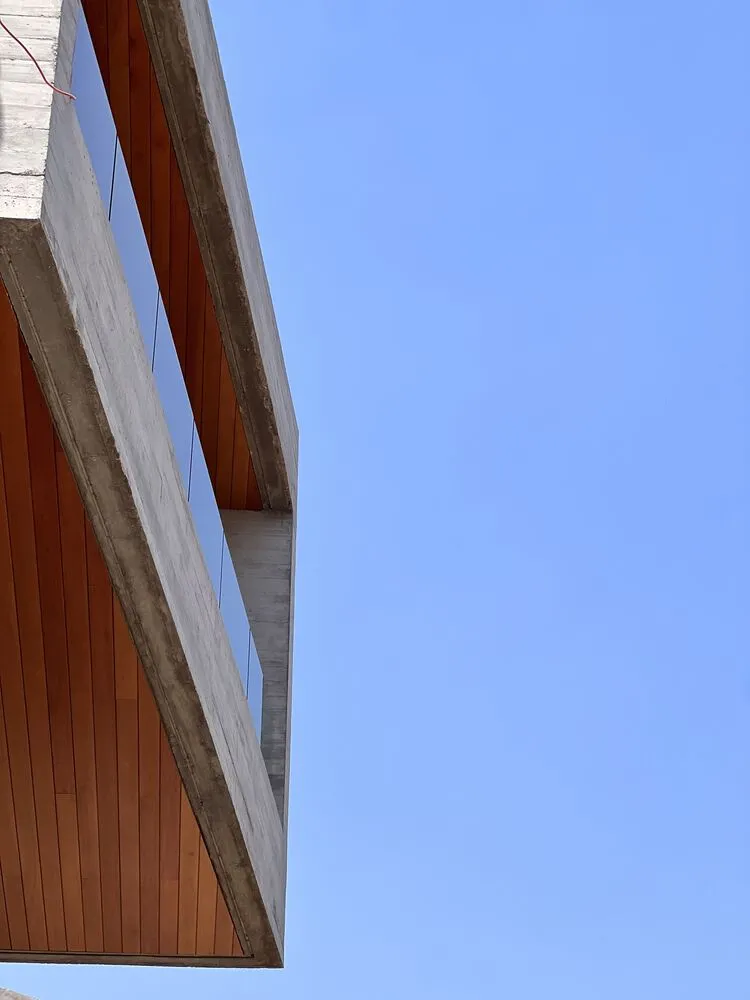 Concrete exterior of a modern building against a clear blue sky.
