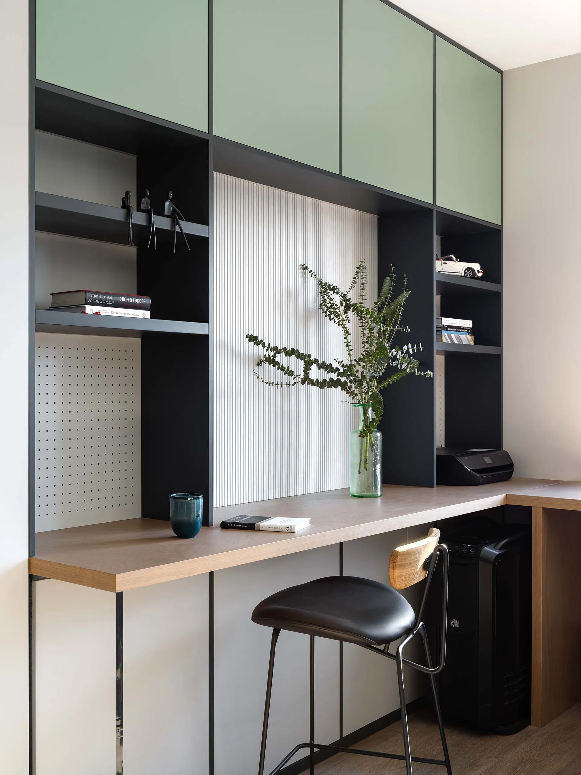 A modern home office space featuring a combination of wood and metal materials, including a desk with shelves, a chair, and d