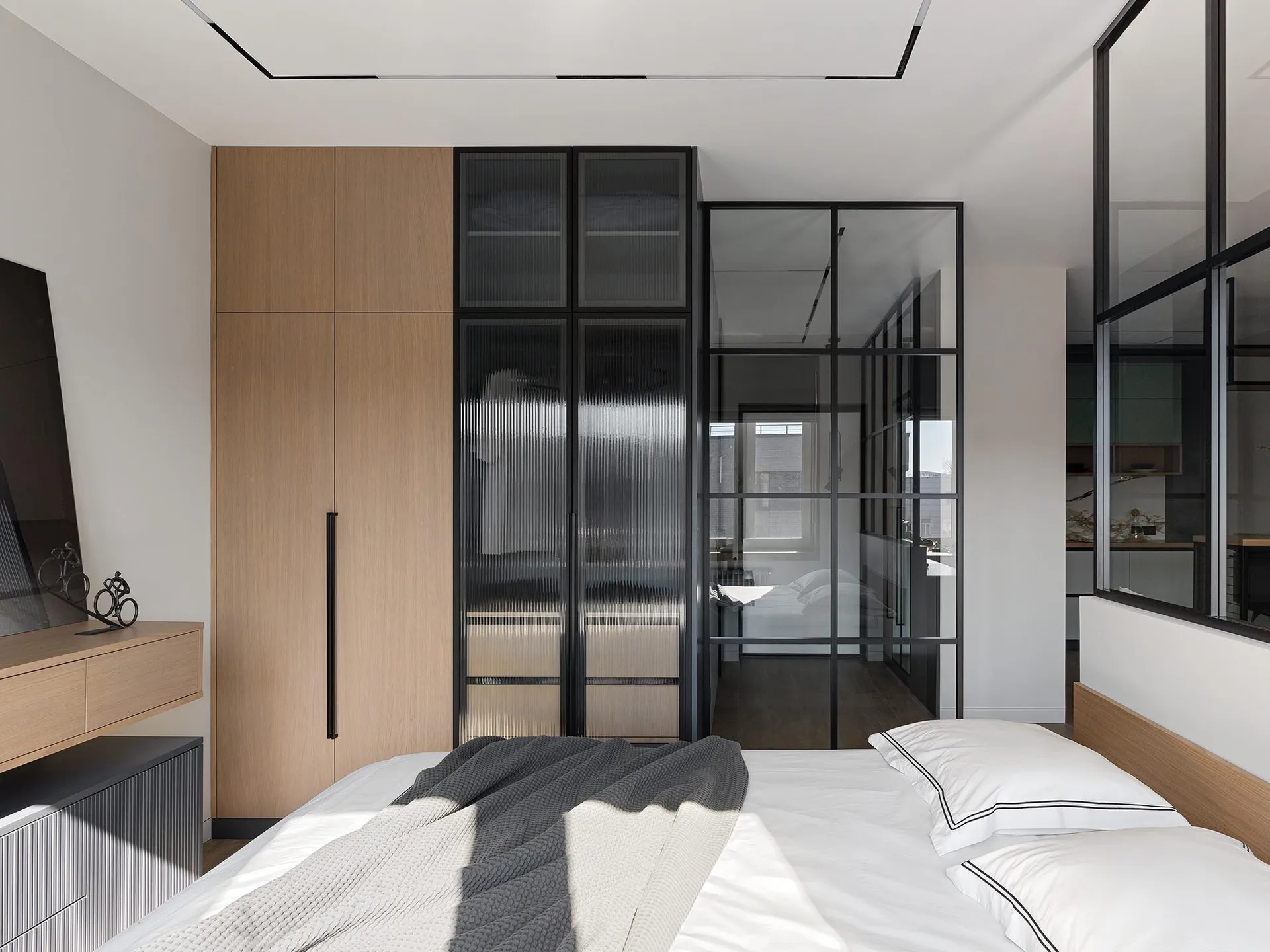 Modern minimalist bedroom featuring a wooden bed and glass closet doors