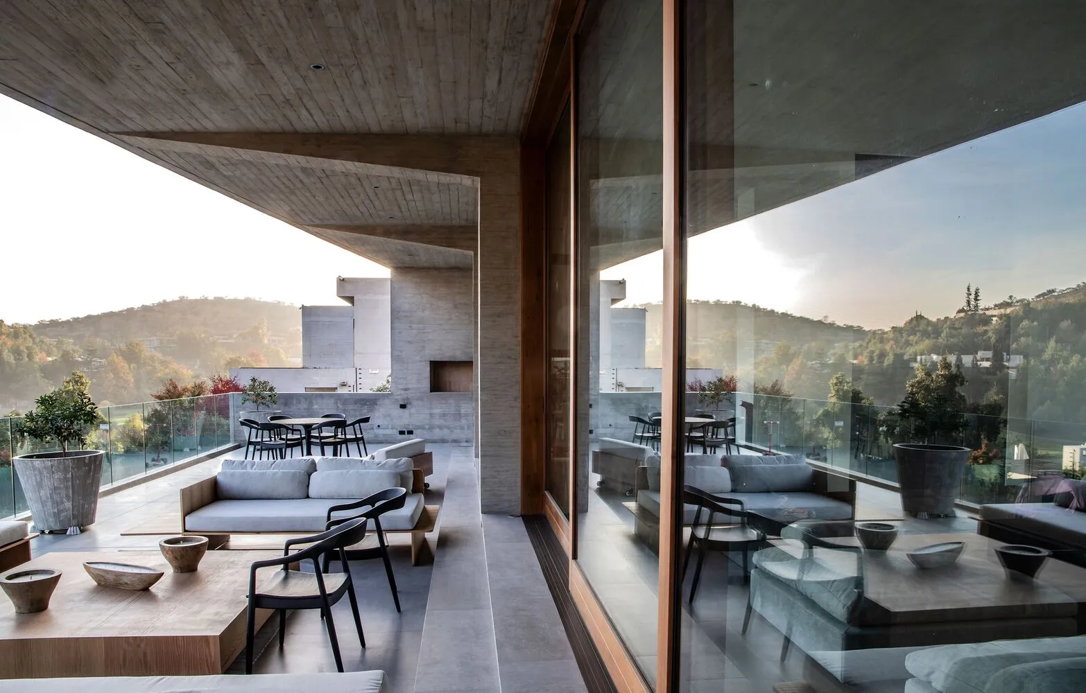 Outdoor living area with modern furniture and concrete walls.