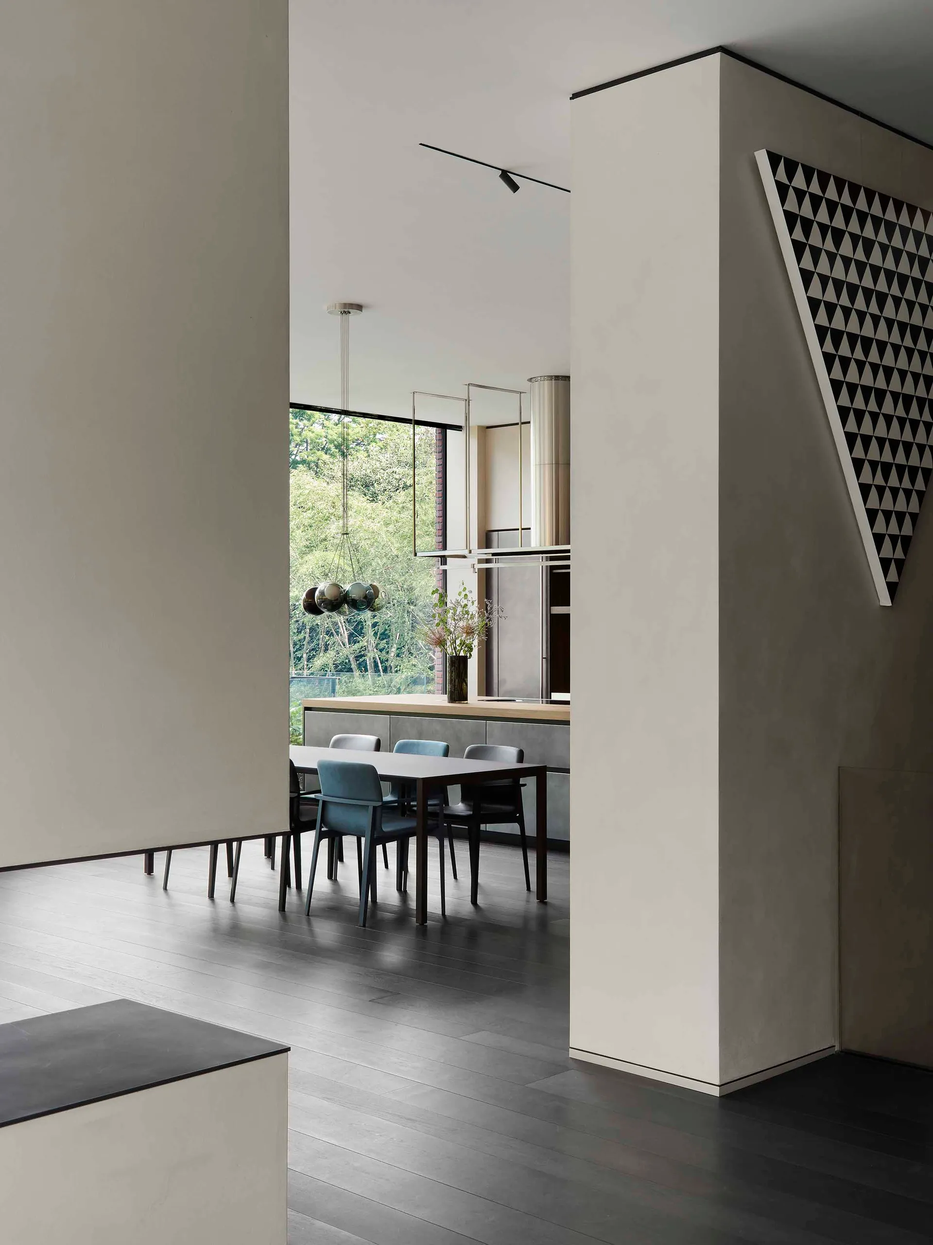 Modern minimalist kitchen with concrete flooring and dining area.