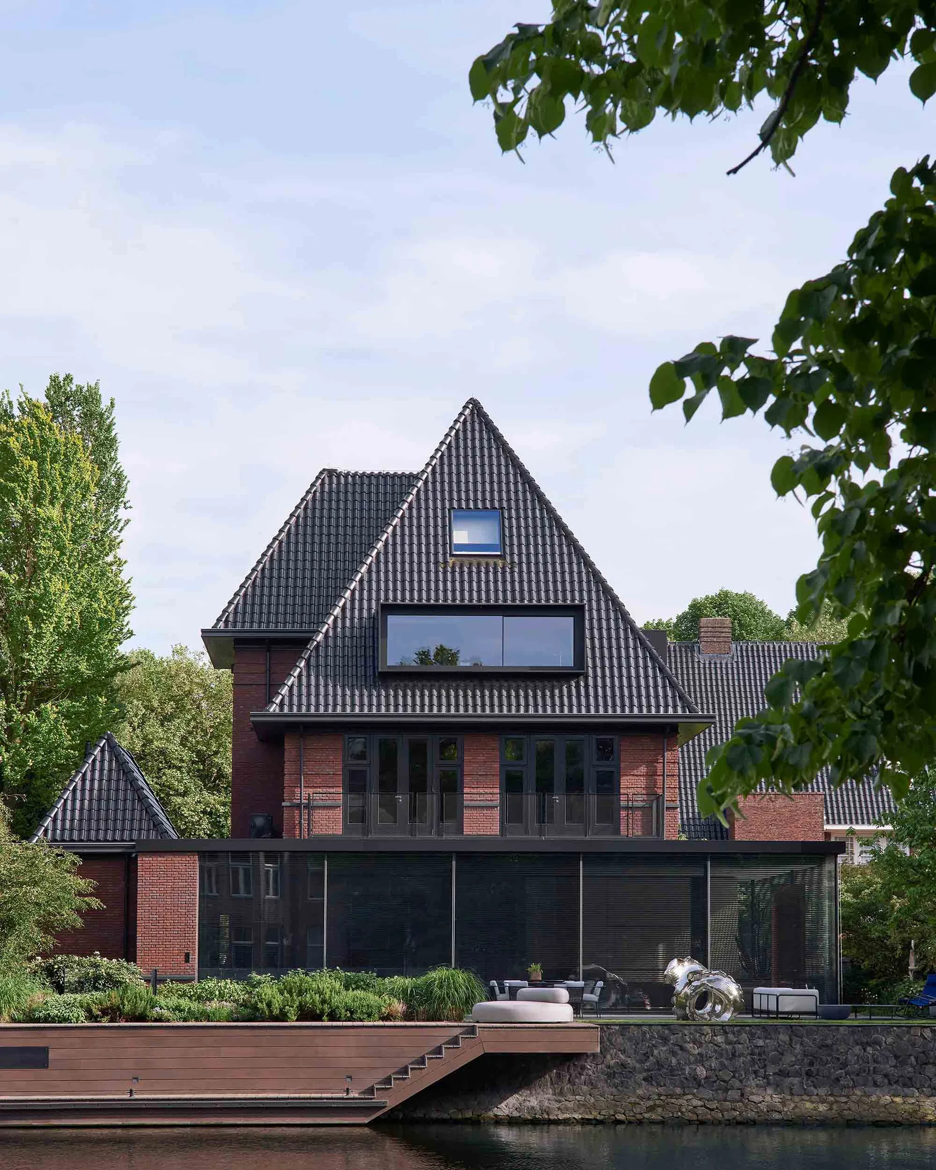 A modern residential house with brick exterior and large glass windows.