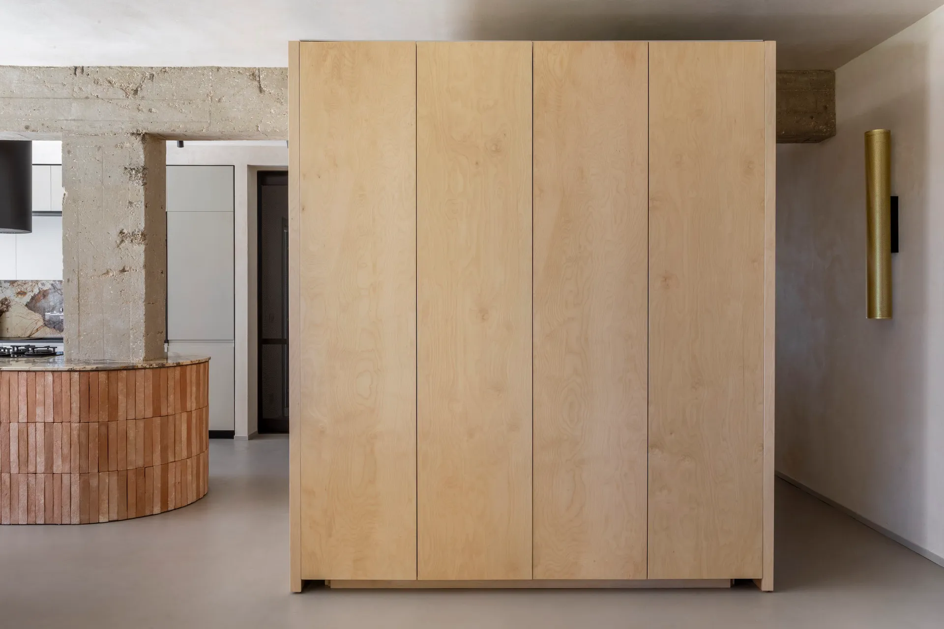 A minimalist wardrobe cabinet made of light-colored wood, featuring four vertical panels.