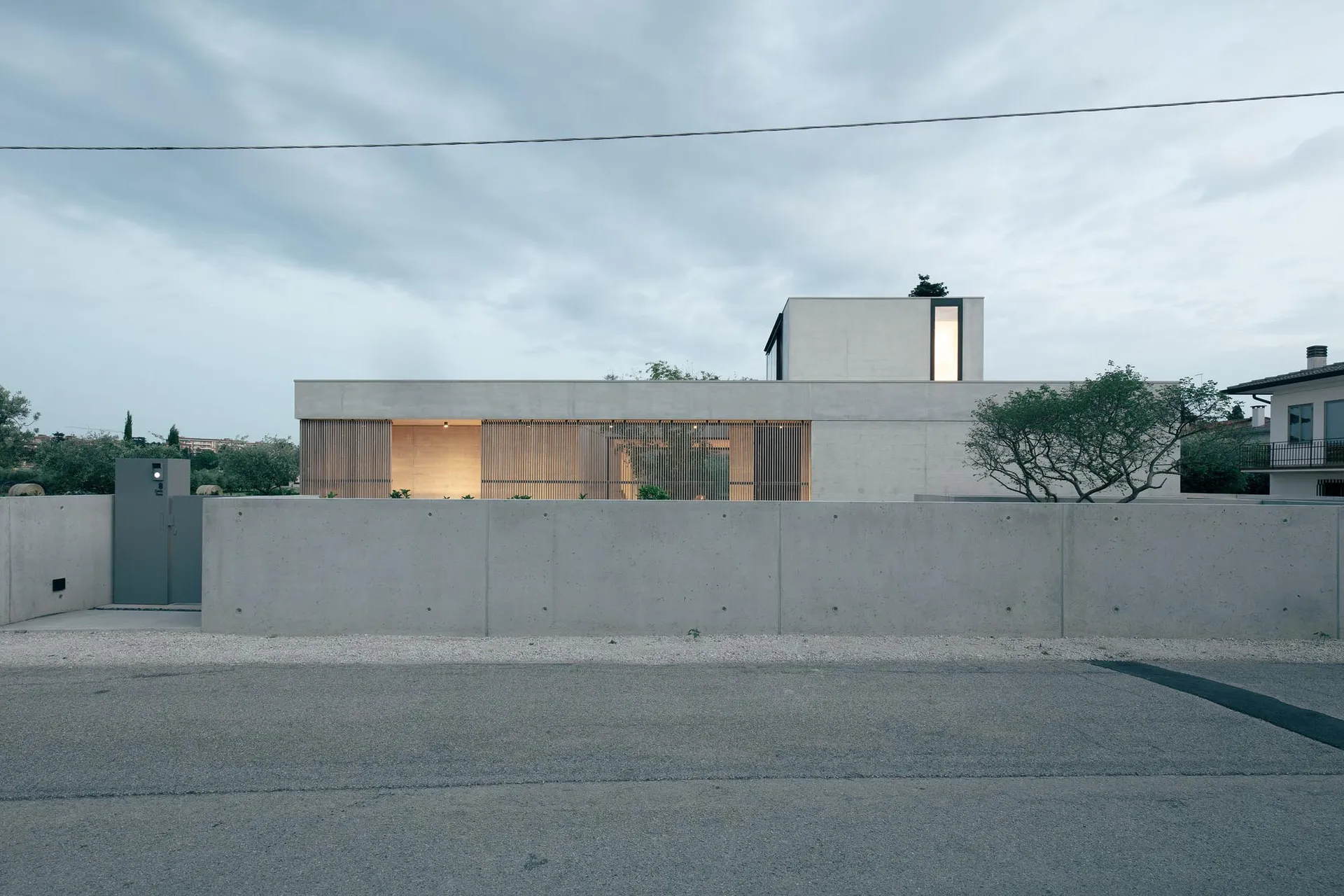 Contemporary residential exterior with sleek lines, concrete materials, and large windows.