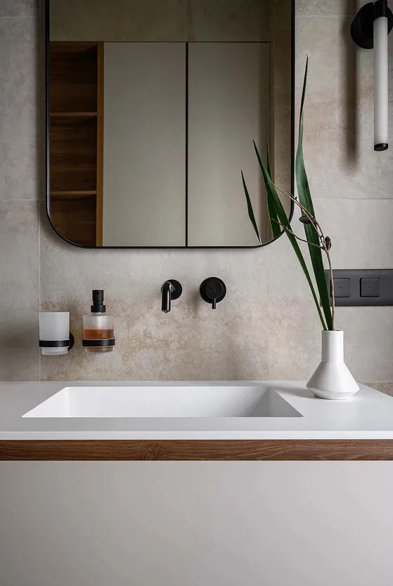 A modern bathroom featuring a floating sink with a white basin and a wooden countertop, set against a concrete and wood wall