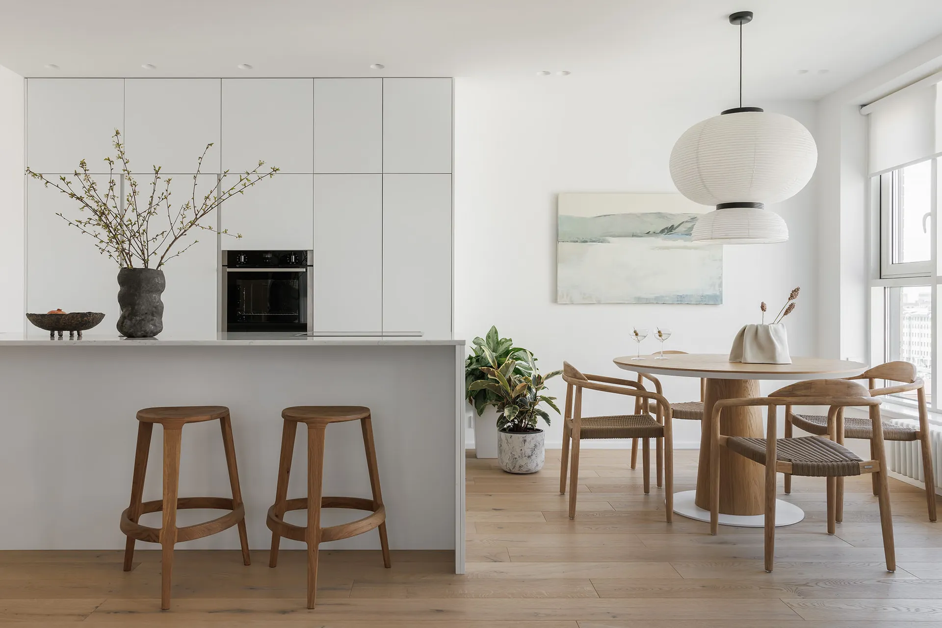 Modern dining room featuring white marble surfaces and wooden furniture.