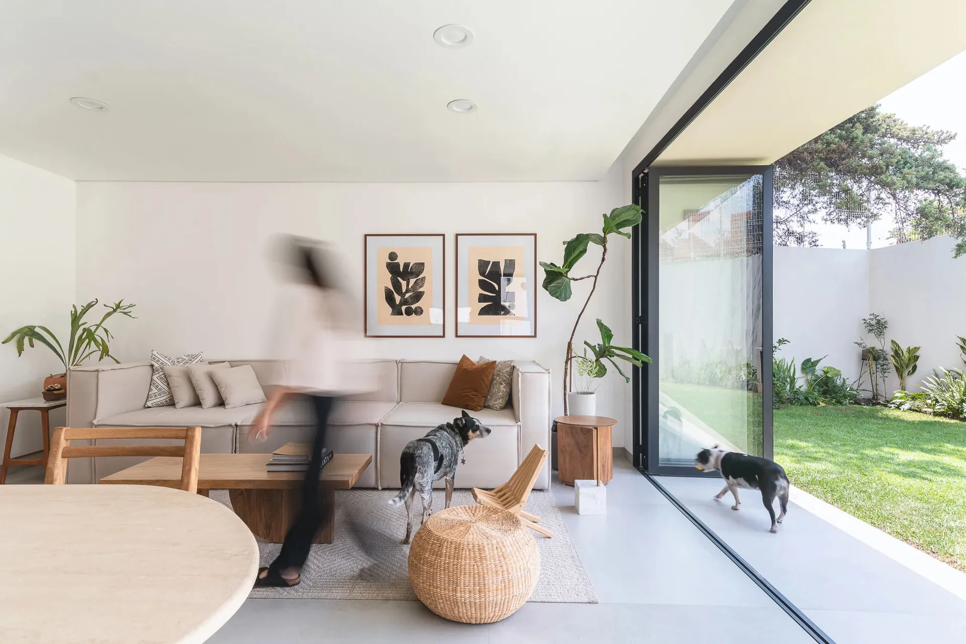 A modern living room with a neutral color palette showcasing plush seating, stylish decor, and a seamless transition to an ou
