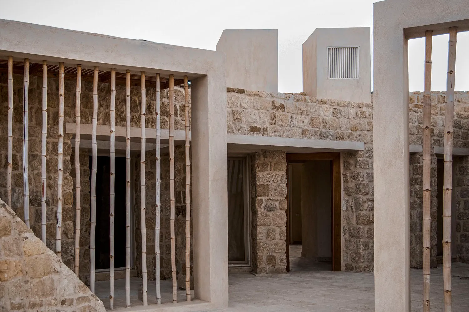 A modernist building exterior made of stone, wood, and concrete.