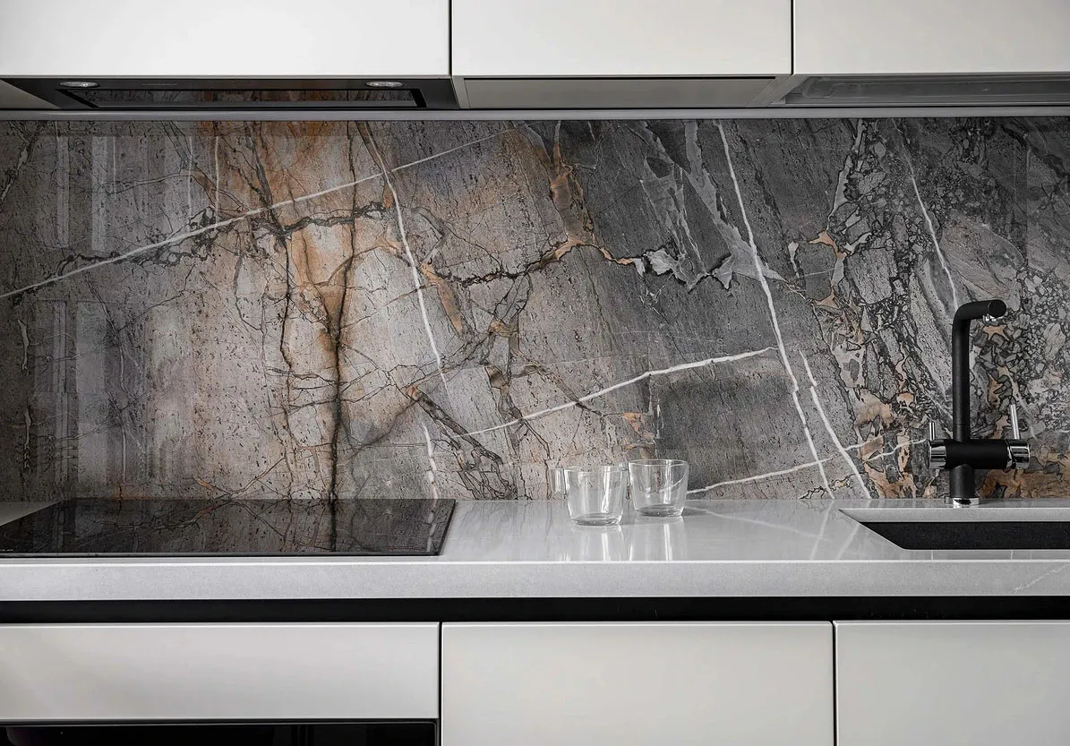 A modern kitchen with granite countertop and backsplash.