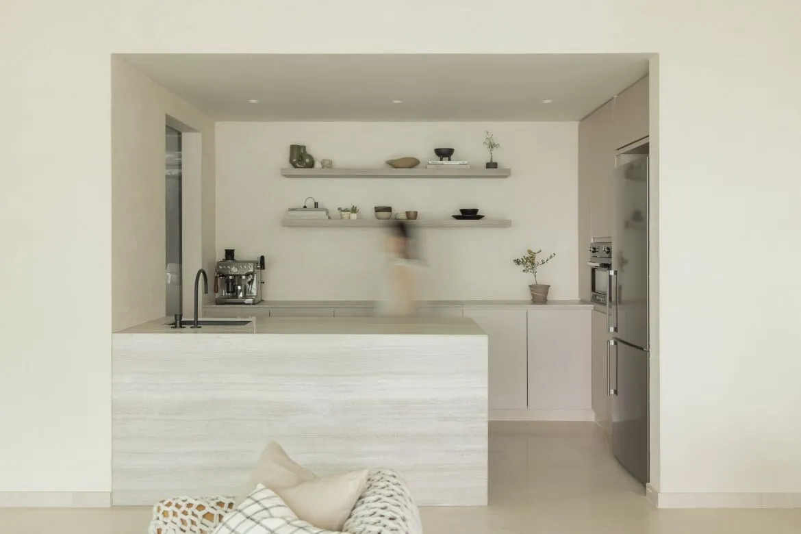 Modern, minimalist kitchen with concrete countertops and shelves.
