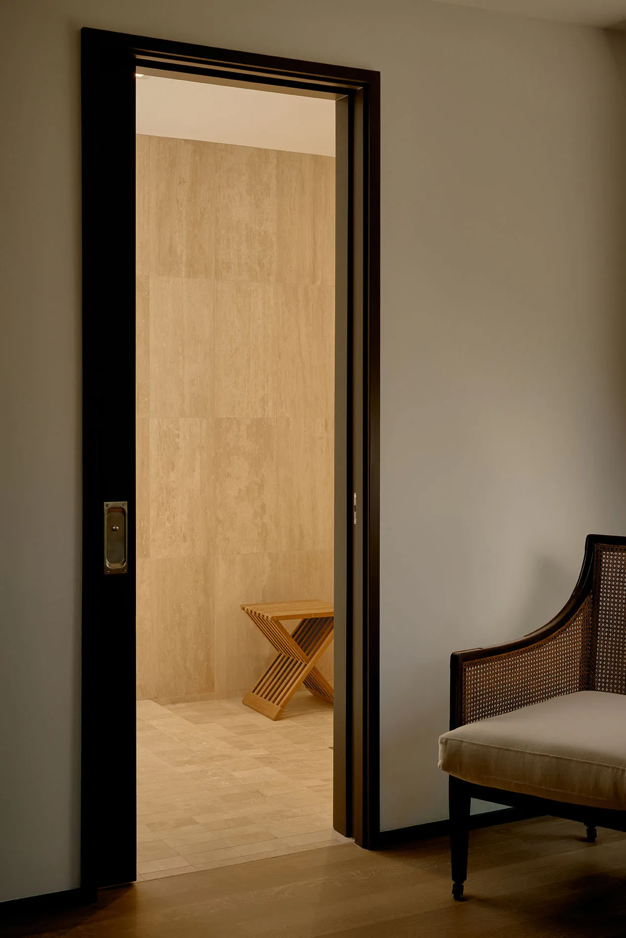 A minimalist doorway leads into a room with a wooden table.