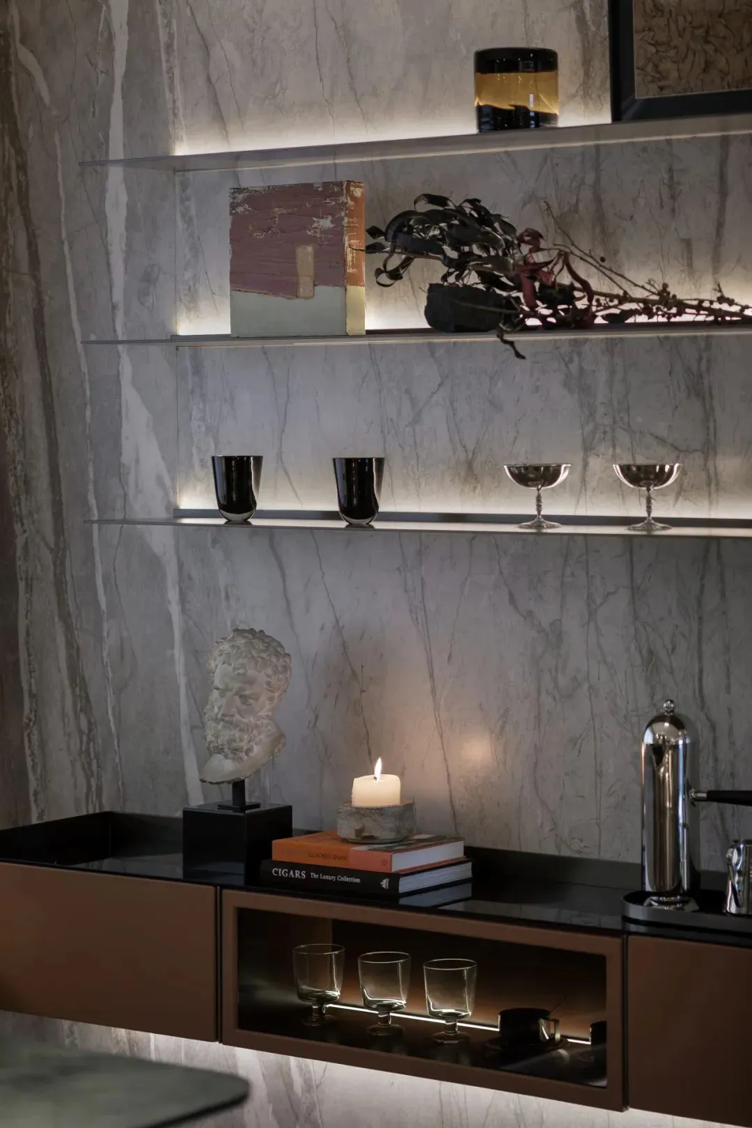 Modern living room with marble accents, glass decor, and metallic elements.