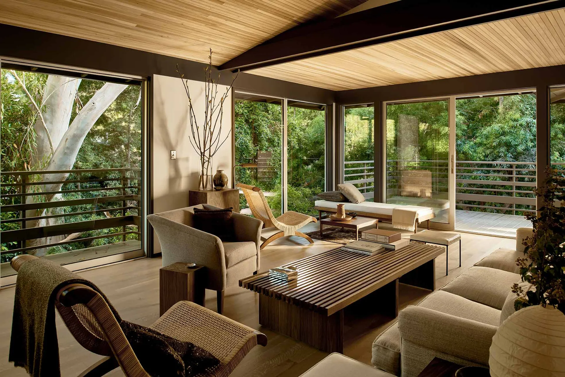 A contemporary living room featuring wooden furniture and a high wooden ceiling.
