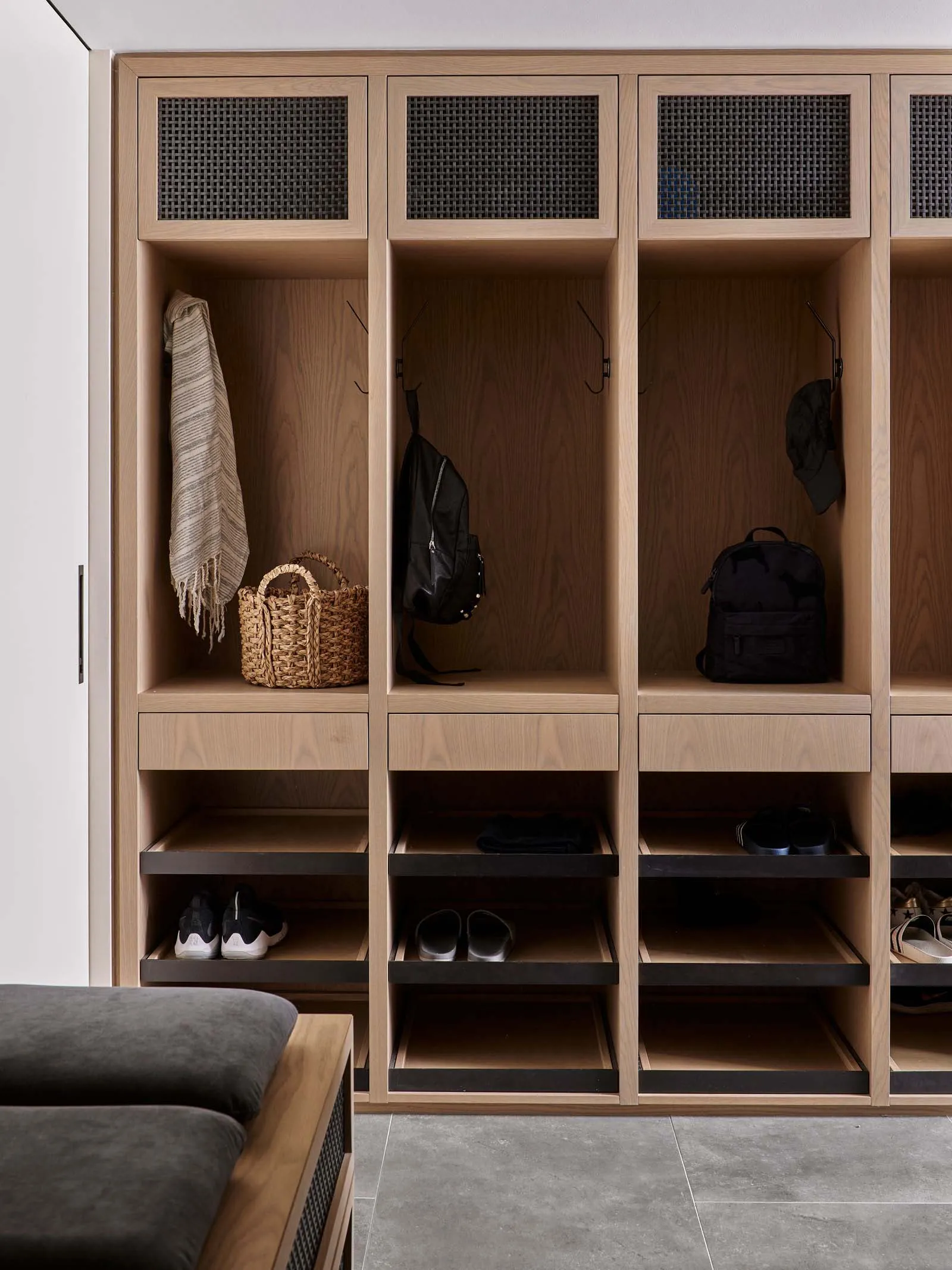 Modern wooden lockers with wicker basket and woven rug hanging.