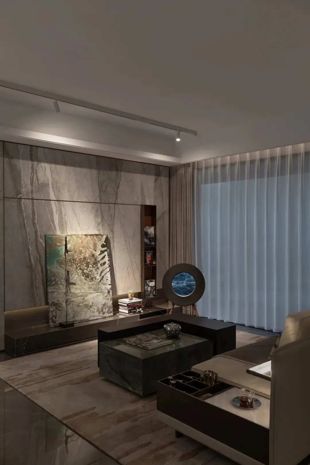 Modern, minimalist living room featuring marble surfaces and neutral tones.