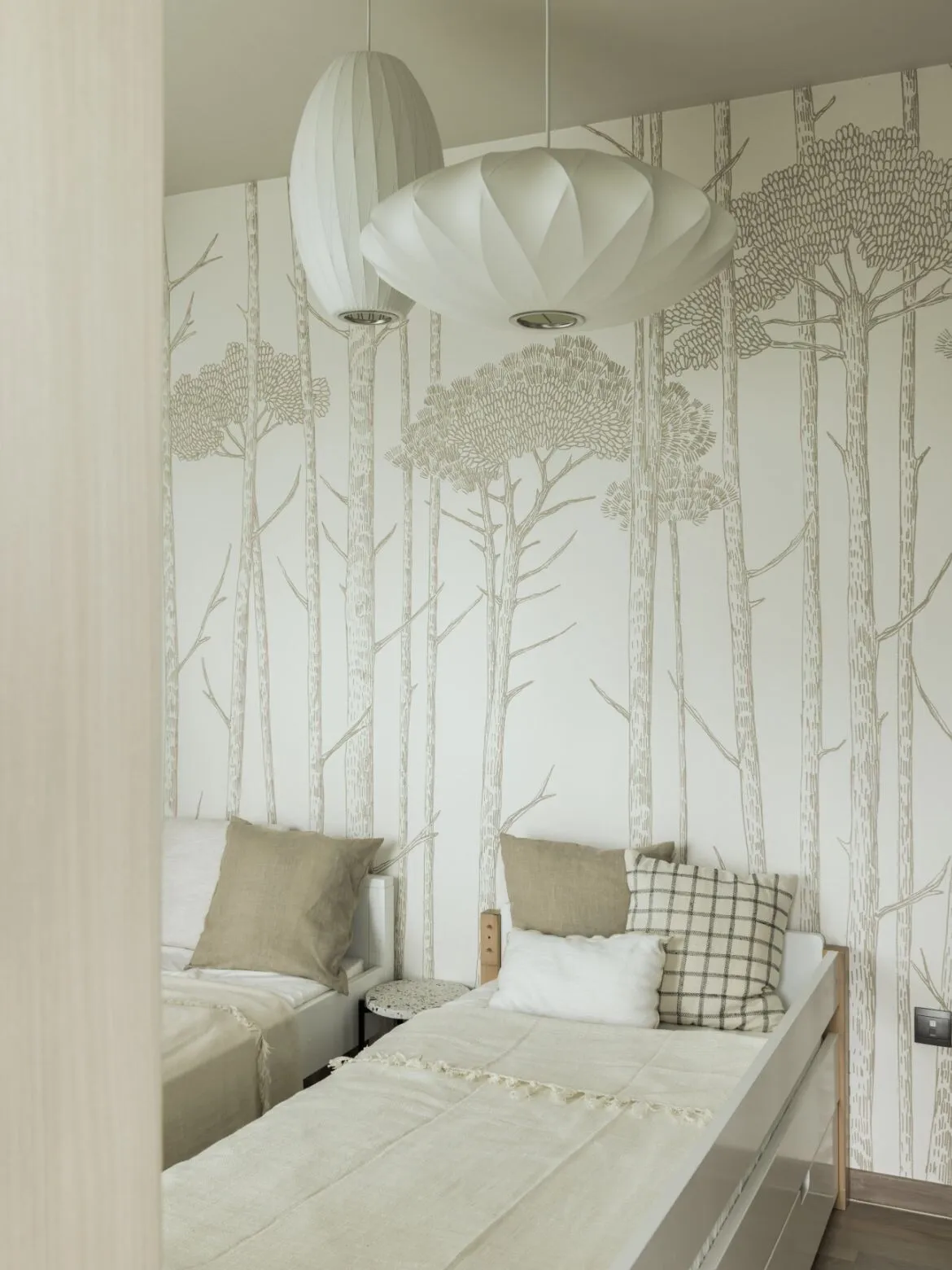 Modern minimalist bedroom with trees patterned wallpaper, linen bedding, and wooden furniture.