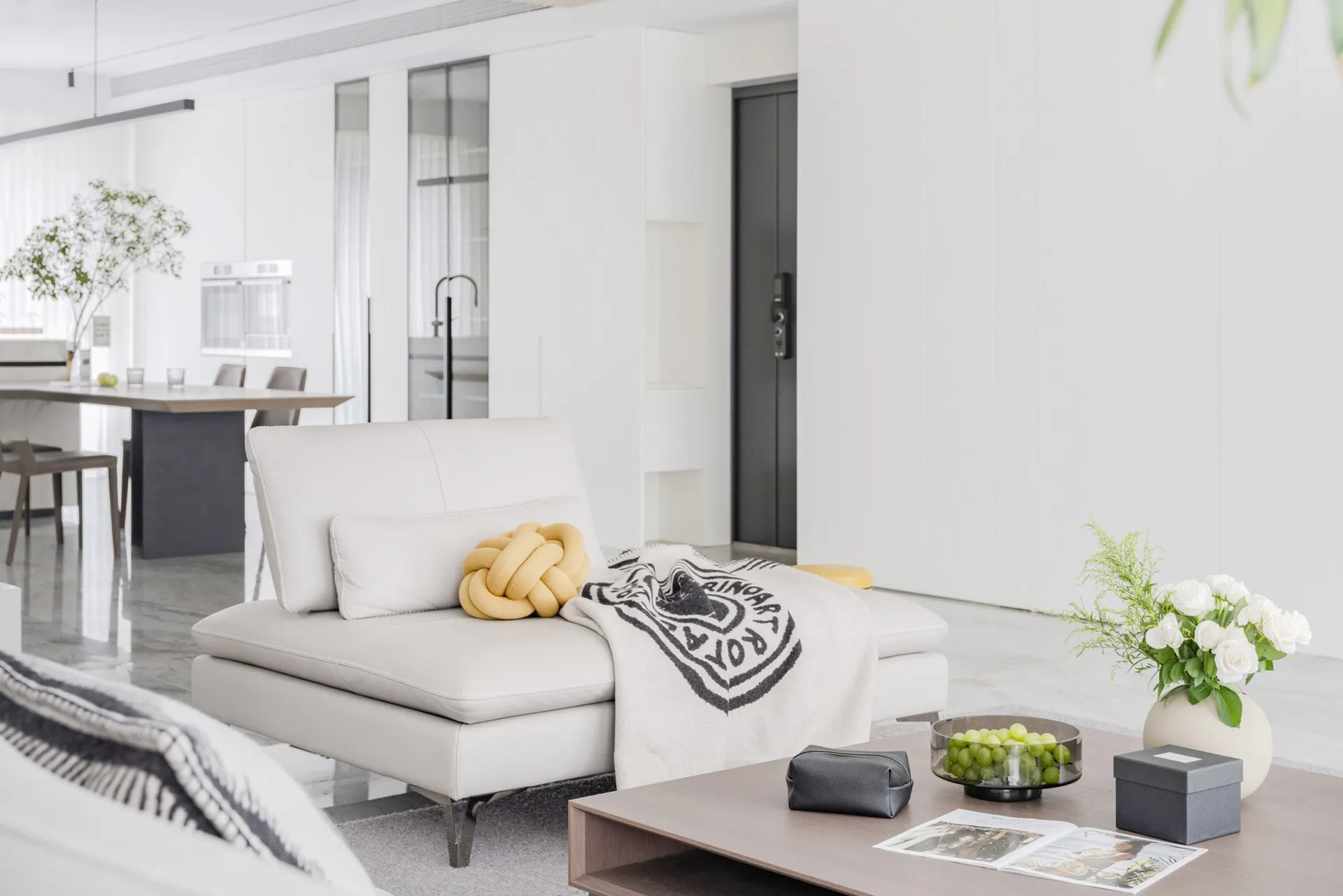 A modern minimalist living room with white leather furniture.