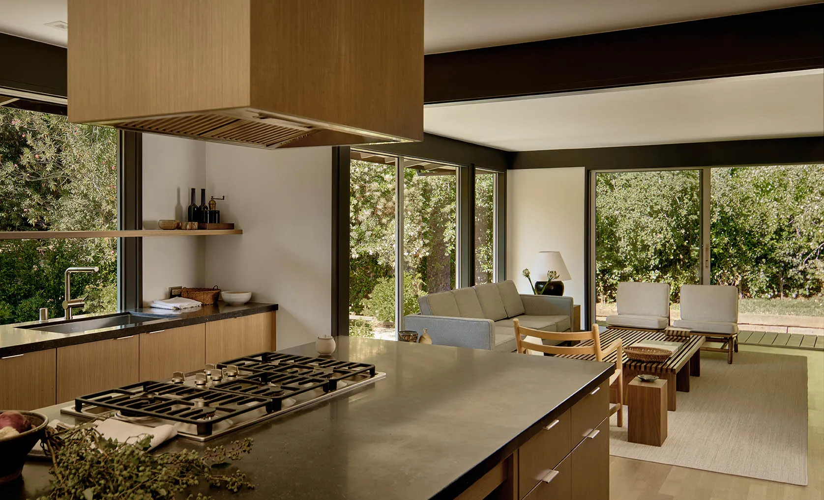 Modern residential kitchen with a wooden and oval-trafalged design featuring a central island with a stove, open shelving, an