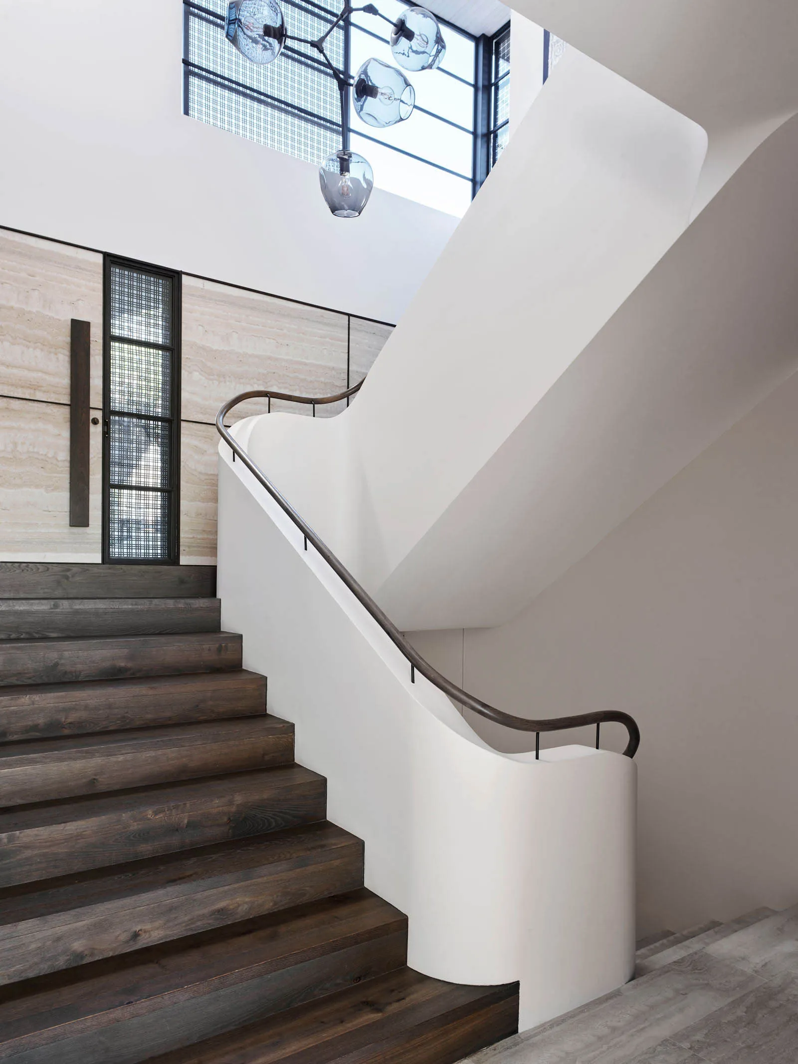 Modern staircase with concrete and wood materials, featuring sleek design and industrial lighting.