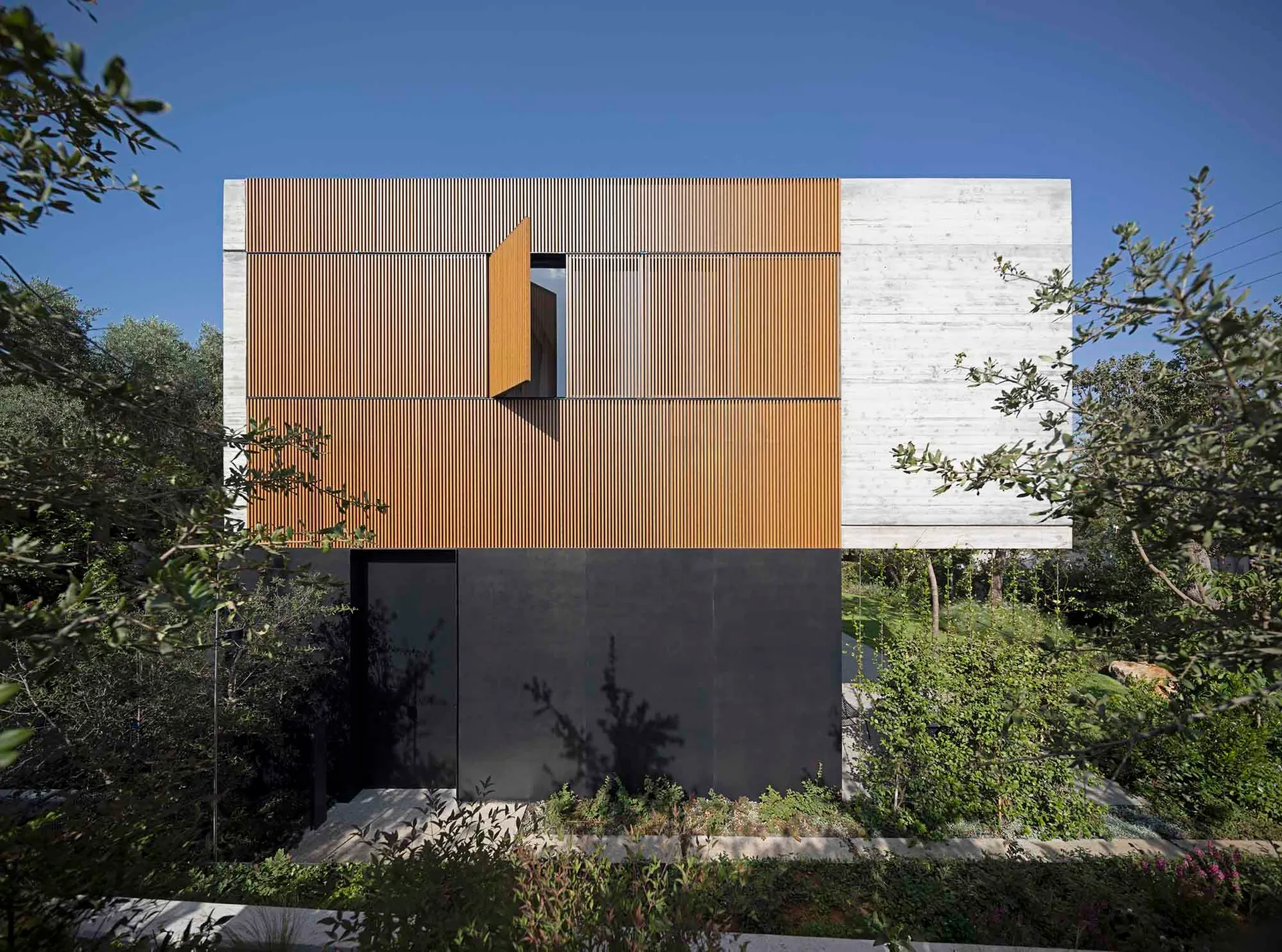 Modern residential exterior featuring a combination of wood and concrete materials.