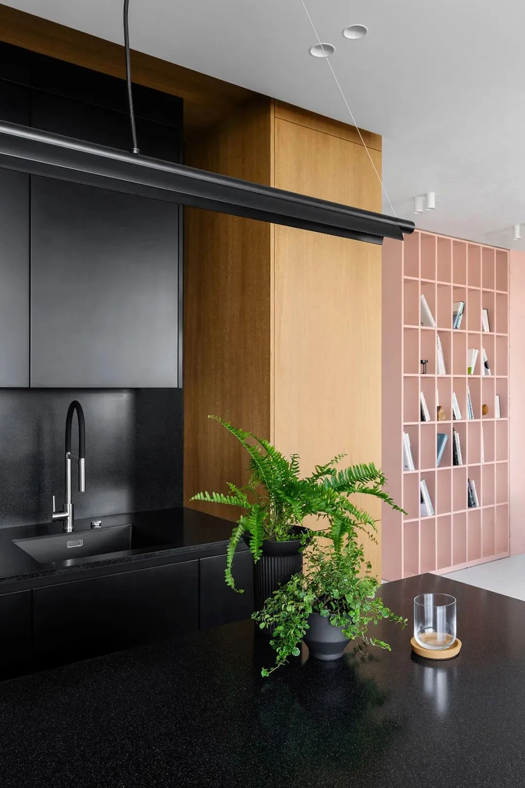 A modern kitchen with black countertops and minimalist design.