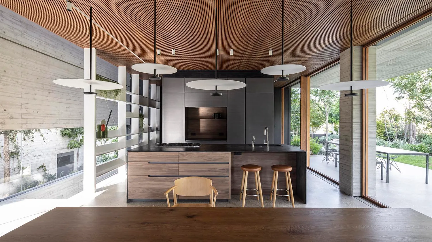 Modern kitchen with wooden accents and a black countertop.